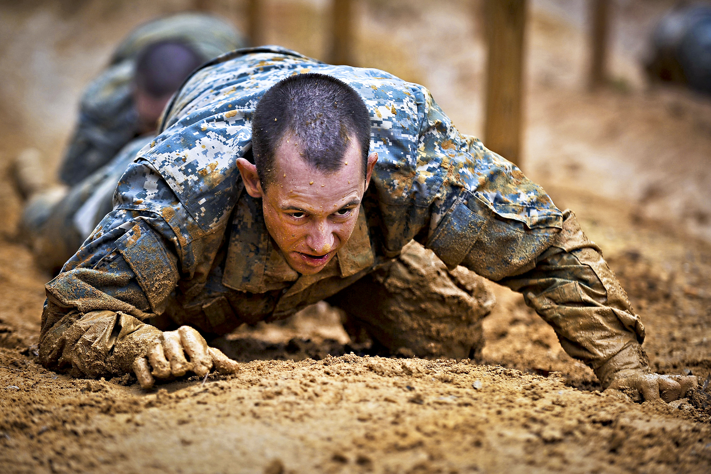 U.S. Army Soldiers from the One Station Unit Training (OSUT) low crawl while negotiating an obstacle course during their first week of Basic Training in Ft. Benning, Ga. March 9, 2012. OSUT is a training program in which recruits remain with the same unit for both Basic Combat Training (BCT) and Advanced Individual Training (AIT). (U.S. Army photo by Staff Sgt. Teddy Wade/ Released)