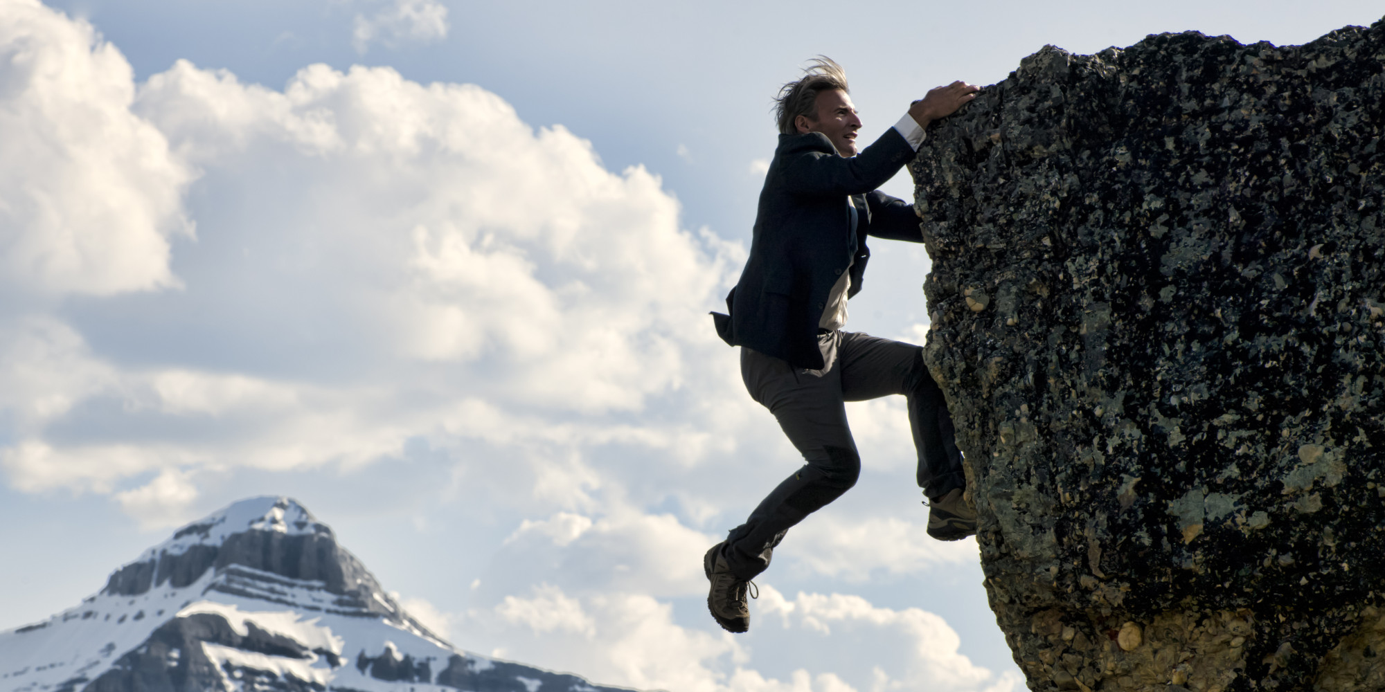 Businessman struggles to climb summit.