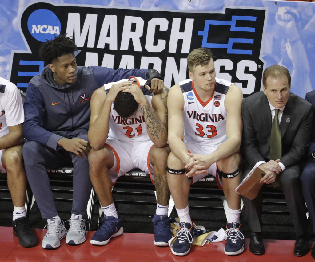 Players on the bench watch as UVA fails to rally against UMBC.