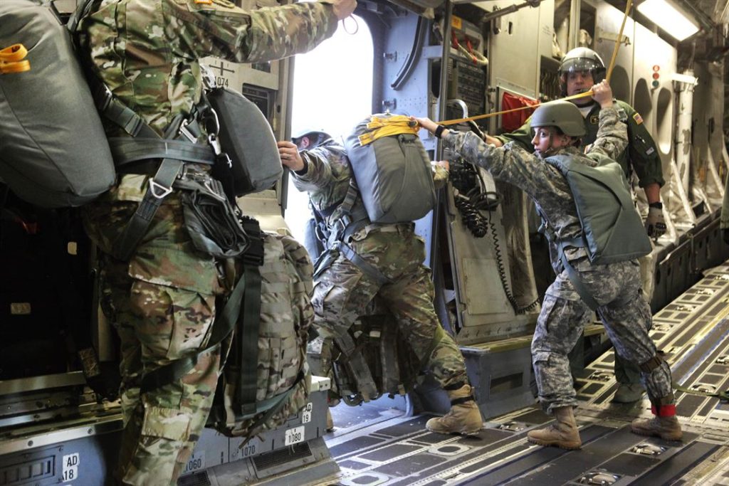 A jumpmaster checking to make sure everything is in order for the paratroopers.